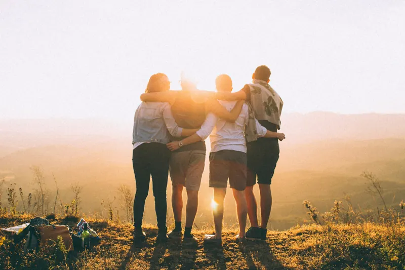 Amigas abraçadas olhando o pôr do sol