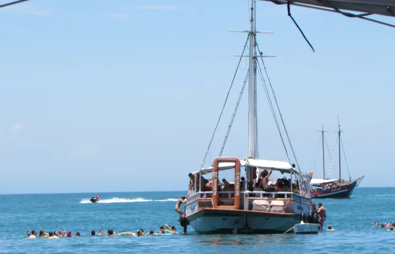 Escuna ancorada com turistas fazendo snorkel ao redor