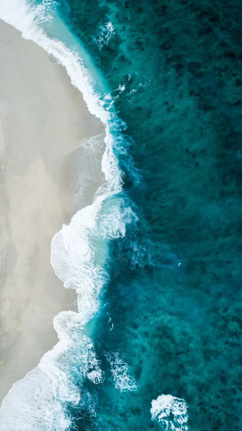 Vista aérea de onda quebrando na areia