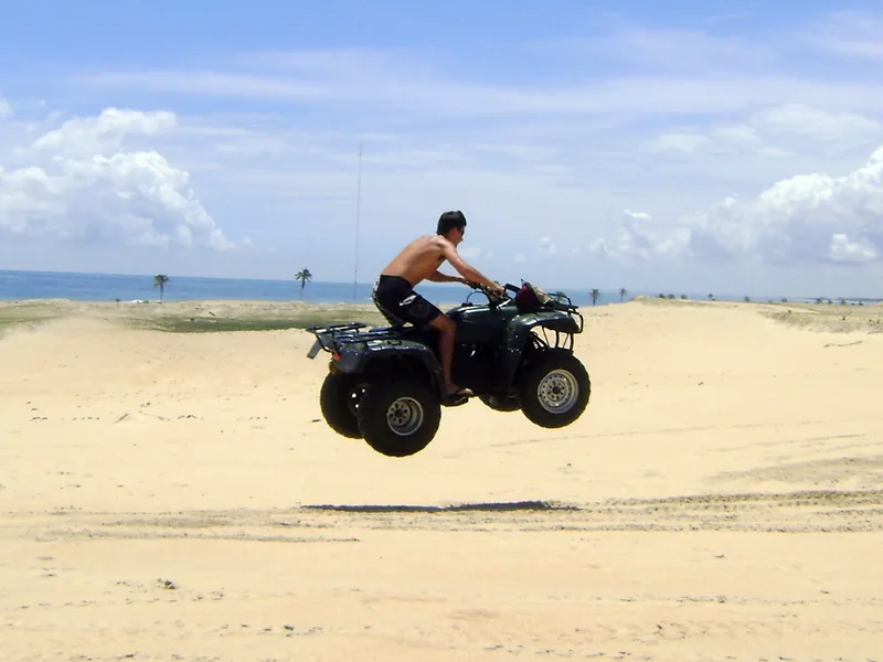 Quadriciclo saltando nas dunas de areia